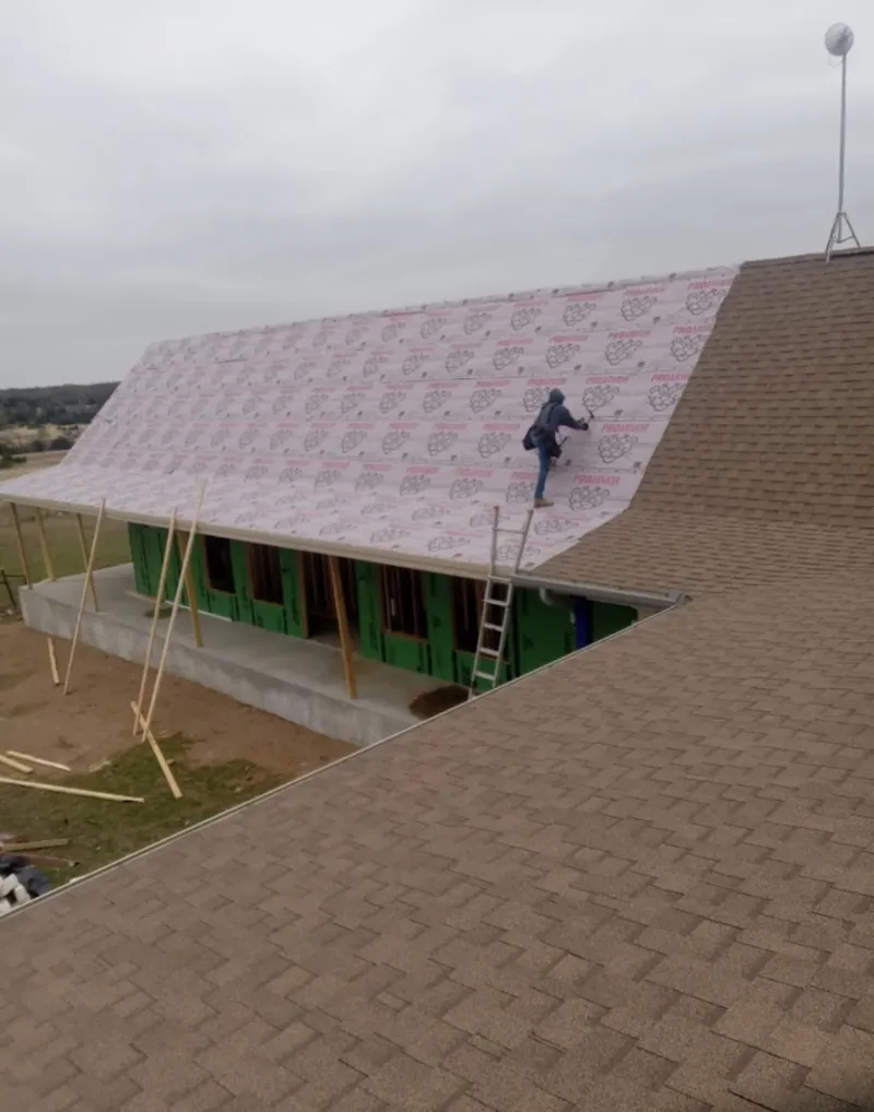 Worker preparing underlayment for a metal roof installation in South Plainfield